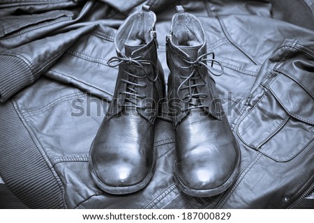Fashionable leather boots and leather jacket. handmade shoes. Photo toned in blue color