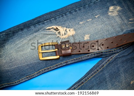 Blue jeans and leather belt with gold buckle