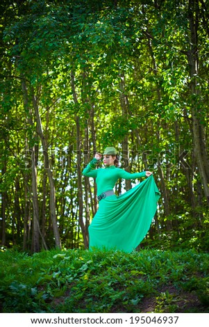 Beautiful girl in green dress in the forest. fashion Photography