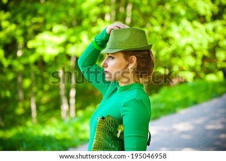 Beautiful girl in a green dress and hat. Face in profile close-up. fashion Photography
