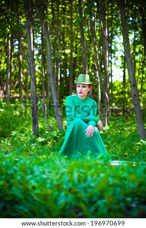 Woman in a green dress in the forest