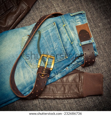 Blue jeans, a leather belt with a buckle and leather jacket