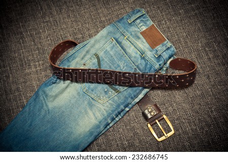 Fashionable clothes: blue jeans and leather belt with buckle