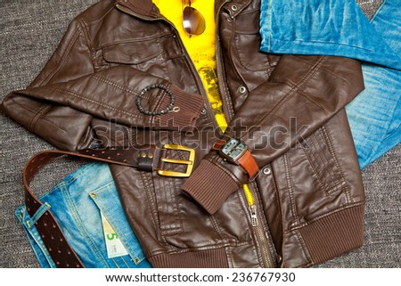 fashionable unisex outfit: leather jacket, T-shirt, jeans with a leather belt, watches, bracelets, sunglasses. Banknote 5 Euro
