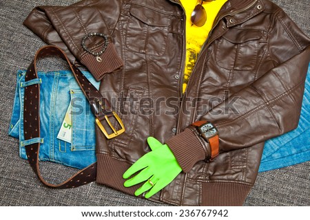 Trendy outfit: leather jacket, T-shirt, jeans with a leather belt, watches, bracelets, sunglasses and gloves. Banknote 5 Euro