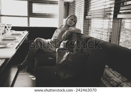 Beautiful woman in a restaurant, looking out the window, waiting for the guests. retro style