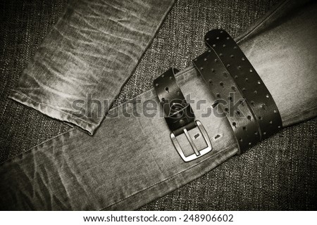 Fashion jeans, a leather belt with a buckle. Black and white photo in retro style