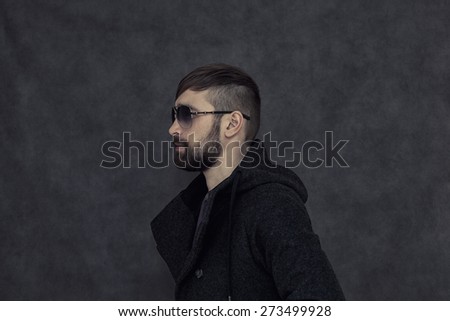 Brutal man with a beard and fashionable hairstyle, sunglasses