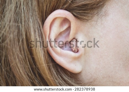 Woman\'s ear with a hearing aid