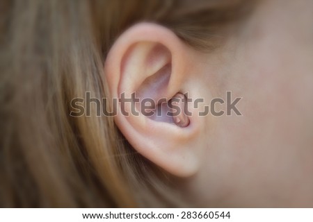 Women\'s ear with a hearing aid