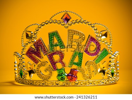 A jeweled Mardi Gras crown on a yello backgroung