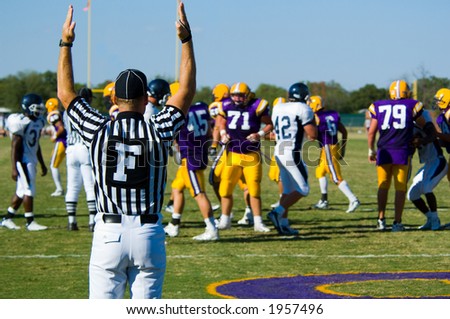 American Football played by young men scoring a touchdown signaled by game official