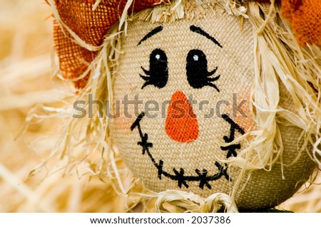 Autumn, fall decoration at pumpkin patch featuring a scarecrow and wagon with straw