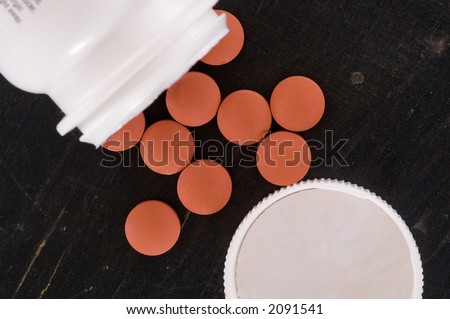 Over the counter medication on black table with bottle and cap