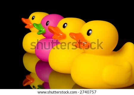 Purple duck surrounded by yellow ducks - illustration of individuality