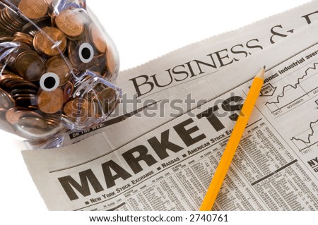Daily newspaper open to business and market related pages with penny bank, idea is that of studying investments