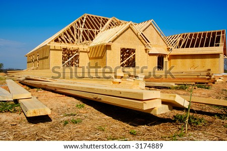 New home under construction with wood, trusses and supplies