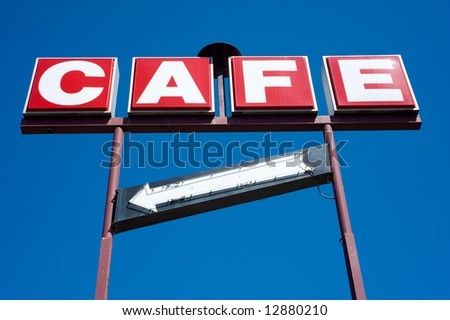 A red and white Cafe sign on a bright blue sky background