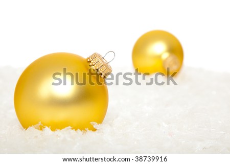 Gold christmas ornaments in snow on a white background