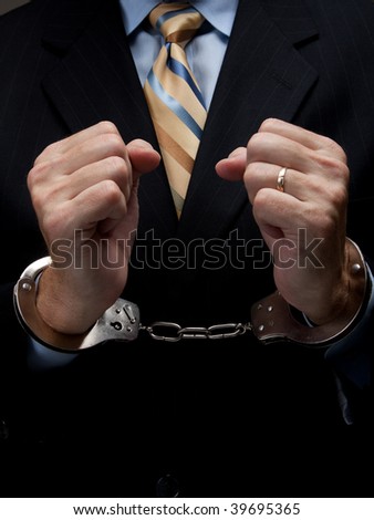 A man in a business suit with handcuffs