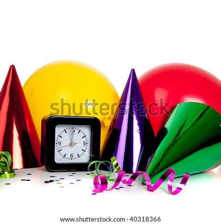 New Year\'s eve decorations including black clock set to midnight and party hats, streamers, confetti and balloons