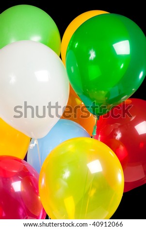 Party balloons including green, white, red, yellow, blue and yellow on a black background