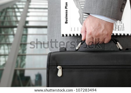 Businessman with business plan and briefcase ready for meeting