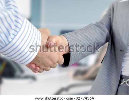 Closeup of businessmen and businesswoman shaking hands.