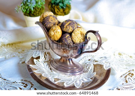 Round shaped cookies decorated with pop seeds in old fashioned sauce-boat