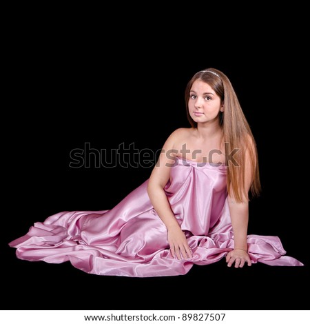 Beautiful young woman wearing a pink dress isolated on black background
