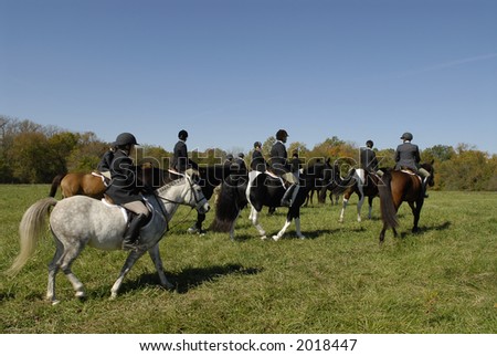 Participating in an equestrian fox hunt.
