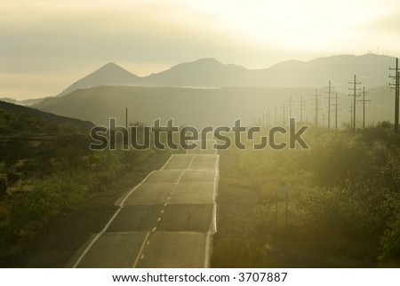 Road to mountains in desert Arizona at sundown.