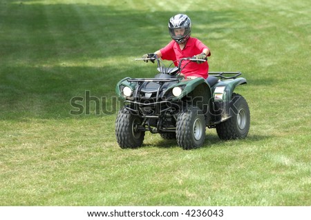 Young boy riding four-wheeler ATV.