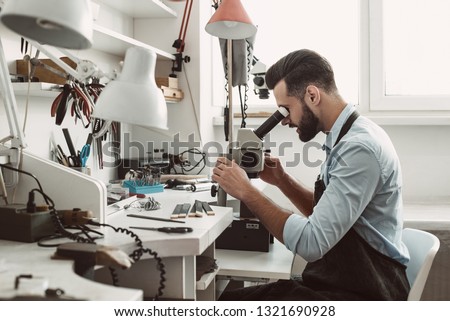 Similar – Image, Stock Photo Mature jeweler creating gold item using a pencil in workshop