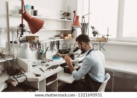 Similar – Image, Stock Photo Mature jeweler creating gold item using a pencil in workshop