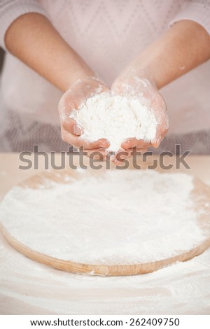 Close up photo of flour in female hands. Concept for cooking in the kitchen