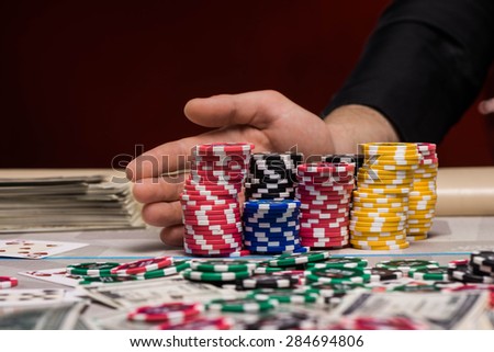Close up photo of young man hand with poker chips at poker table