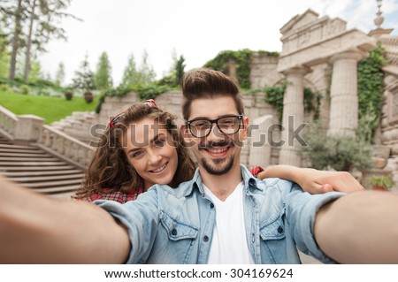 Portrait of beautiful young woman and handsome man on vacation. Girl and boy making self portrait and smiling