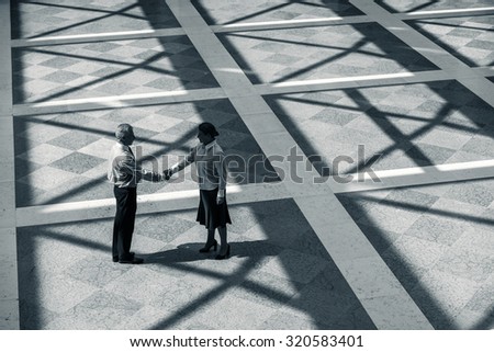 Top view photo of creative business people. Business people standing on marble floor and shaking hands while meeting