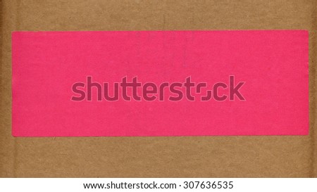 Pink paper tag or label or sticker for product information on a corrugated cardboard box packet