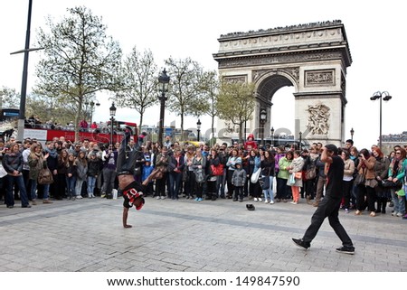 PARIS - APRIL 27: B-boy doing some breakdance moves in front a street crowd, at Arch of Triumph, April 27 2013, Paris, France