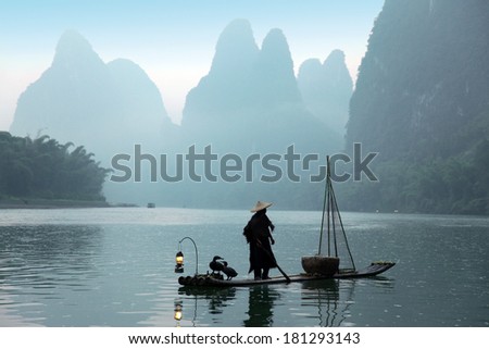 Chinese man fishing with cormorants birds in Yangshuo,traditional fishing use trained cormorants to fish, China