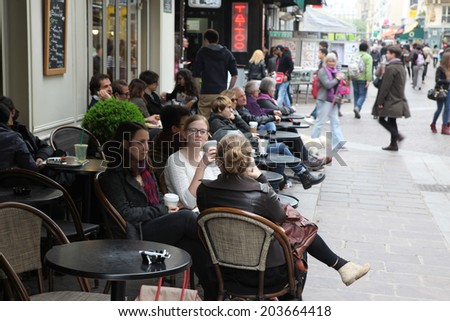PARIS - APRIL 27 : Parisians and tourist enjoy eat and drinks in cafe sidewalk in Paris, France on April 27, 2013. Paris is one of the most populated metropolitan areas in Europe