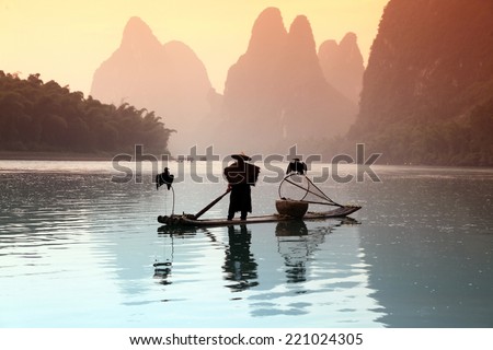 Chinese man fishing with cormorants birds in Yangshuo, traditional fishing use trained cormorants to fish, China