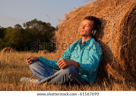 The young man on the nature listens to music