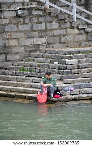 GUILIN, CHINA - APRIL 11: Women washing their clothing along Li River on April 11, 2011 in Guilin, China. Li river provides clean water to the residents for their daily usage.