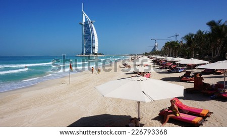 DUBAI, UNITED ARAB EMIRATES -OCTOBER 18, 2014: People on the Jumeirah Beach in Dubai, UAE. Jumeirah Beach is a white sand beach that is located and named after the Jumeirah district of Dubai.