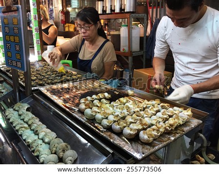 KAOHSIUNG, TAIWAN - NOV 27: Chief prepares seafood to be sold in Kaohsiung night market on November 27, 2014. People enjoy food at night market in Taiwan. And is one of the unique culture in Taiwan.