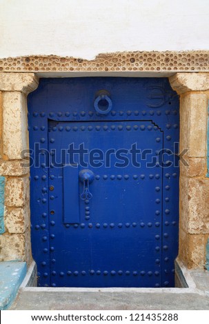 Typical, old, blue intricately carved, studded, Moroccan riad door and door-frame, Azemmour, El Jadida, Morocco.
