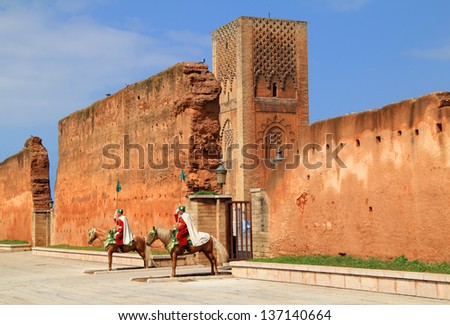 RABAT, MOROCCO - MARCH 13: Royal mounted guards on Arab horses and The Hassan Tower inside the Mausoleum of Mohammed V complex, Rabat\'s most visited tourist icon. On March 13, 2013 in Rabat, Morocco.